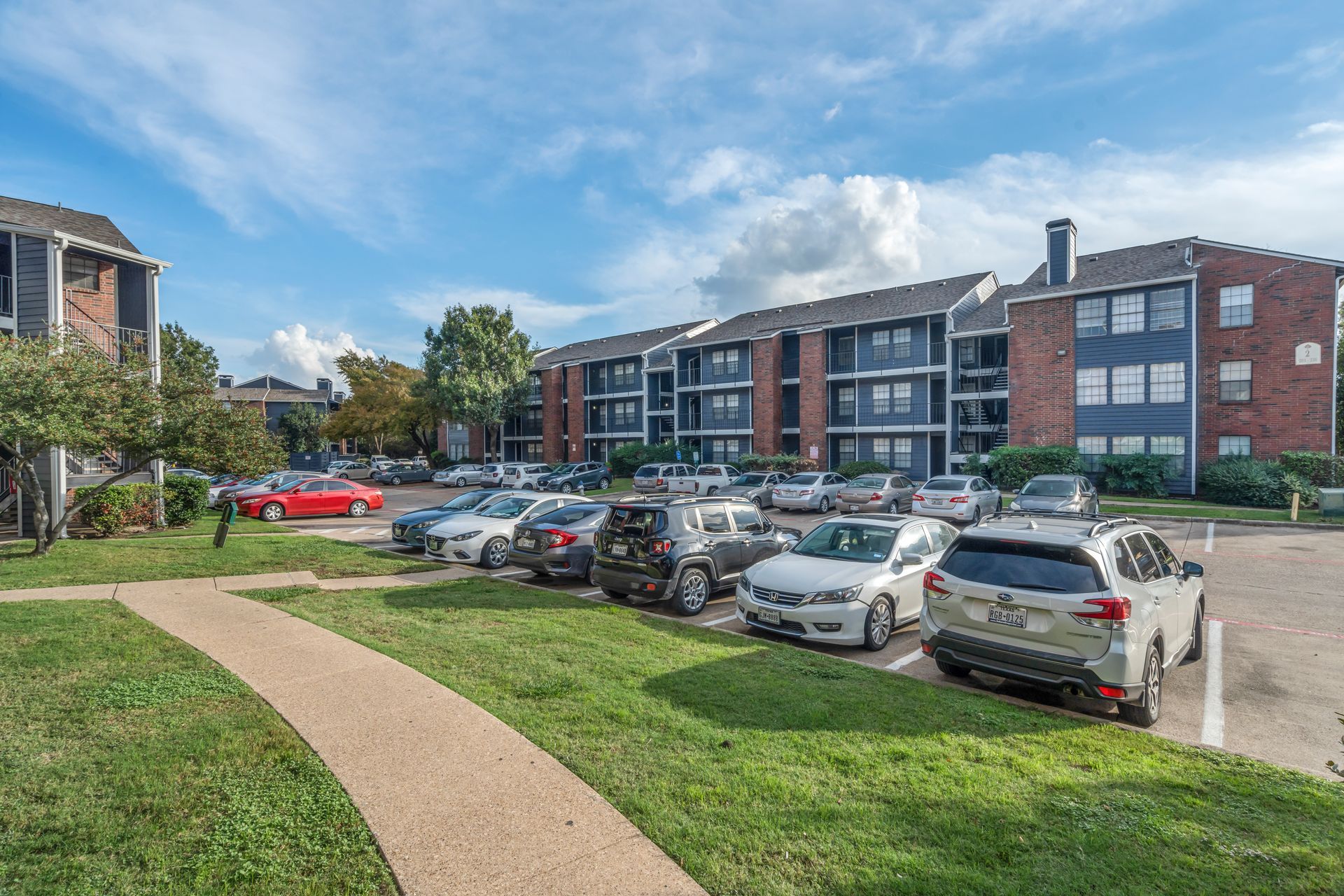 A parking lot with a lot of cars parked in front of a building.
