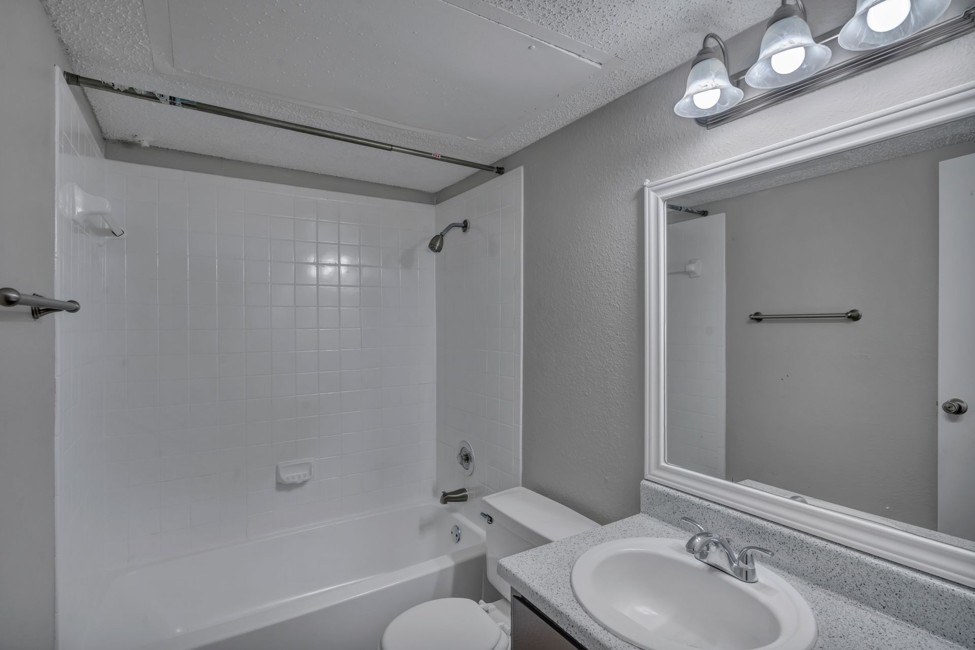 A bathroom with a sink , toilet , bathtub and mirror.