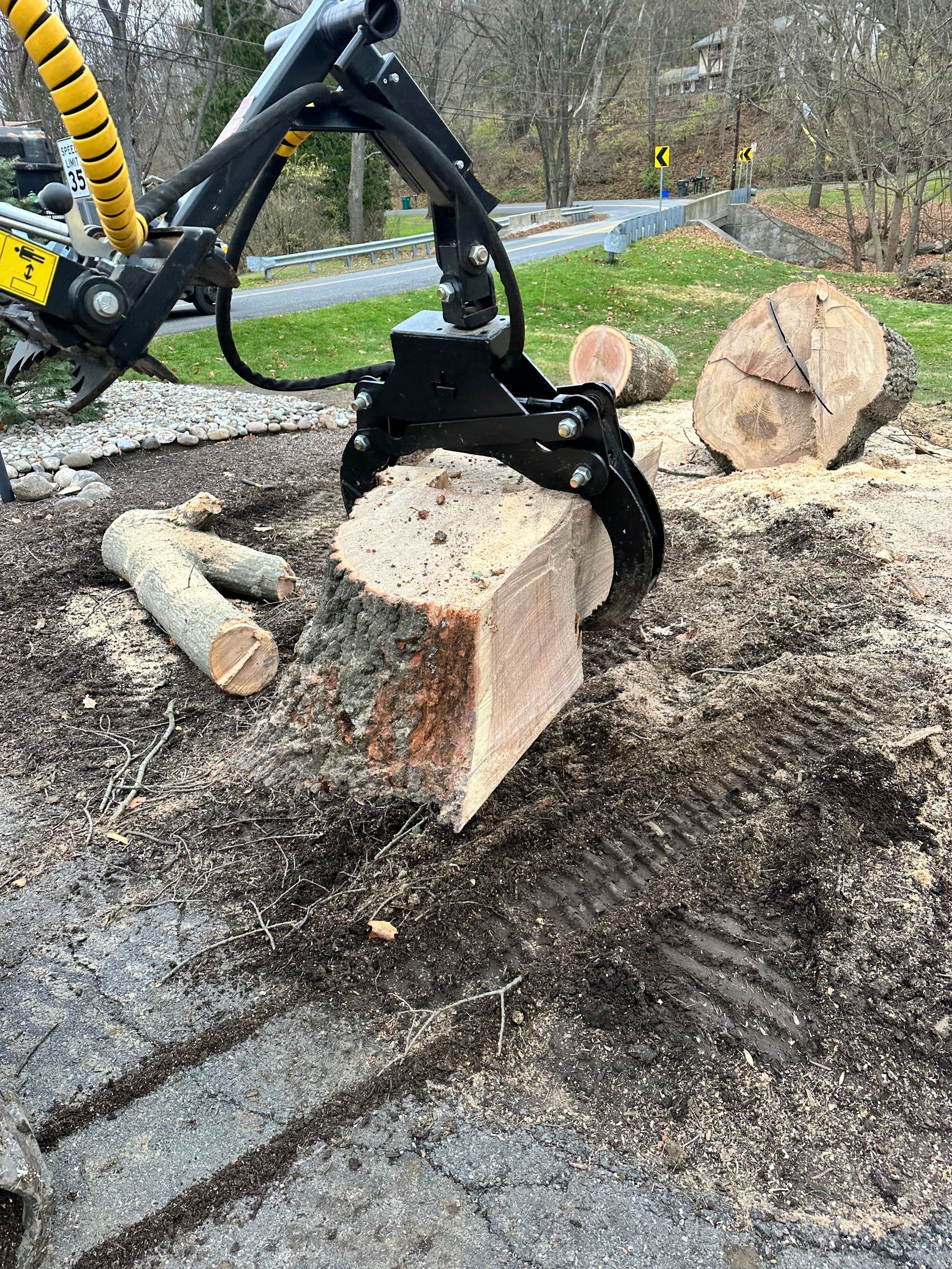 a large piece of wood is being lifted out of the ground by a machine .
