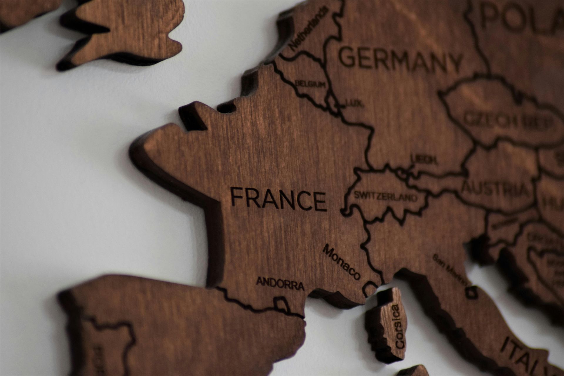 Carte en bois de l'Europe, centrée sur la France, avec les noms des pays gravés.