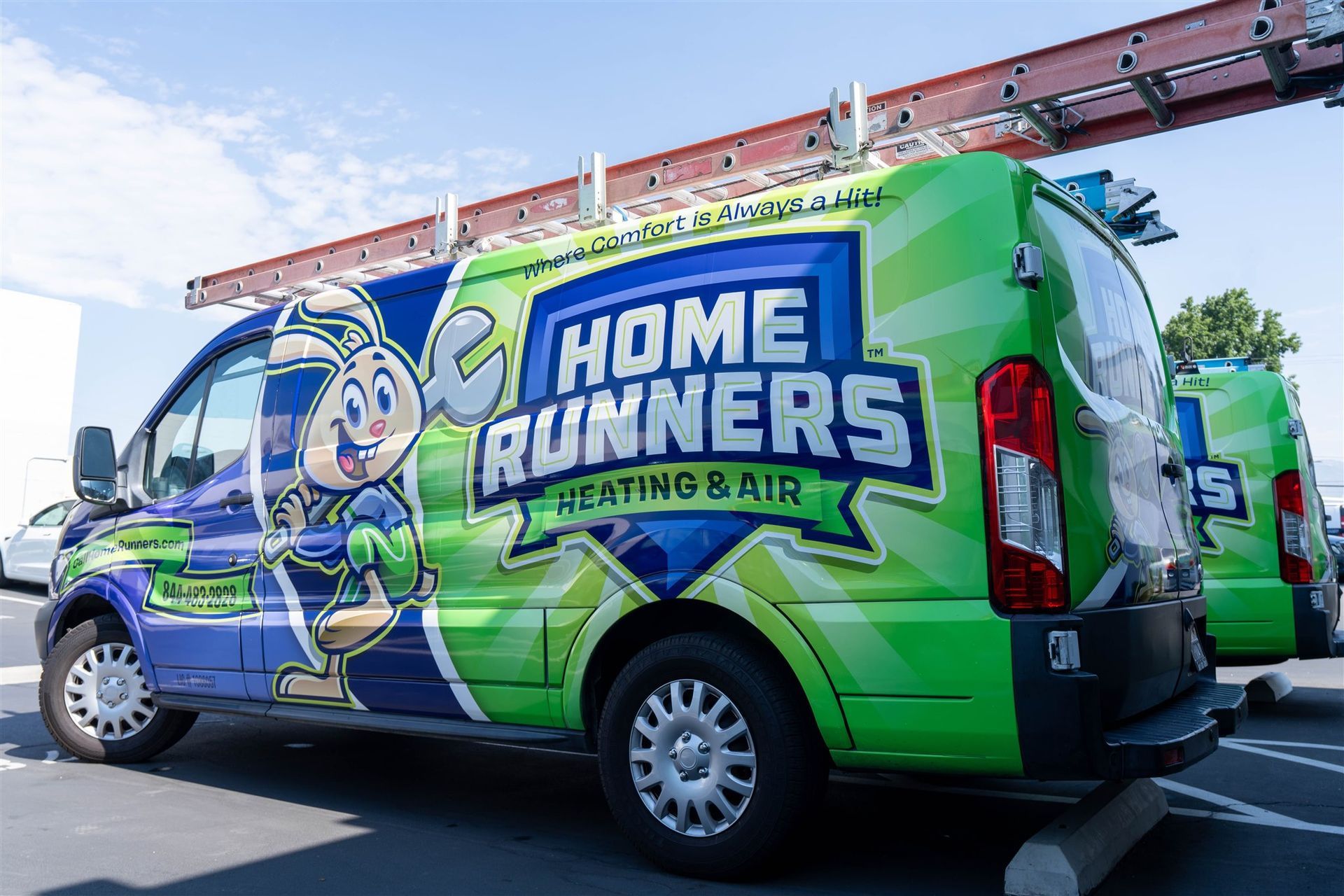 Bright green and blue Home Runners Heating & Air van with cartoon character, parked outdoors.
