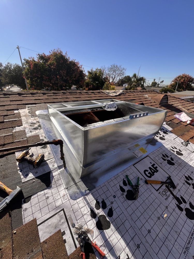 Metal roof vent on a shingle roof with GAF underlayment, tools, and a clear blue sky.