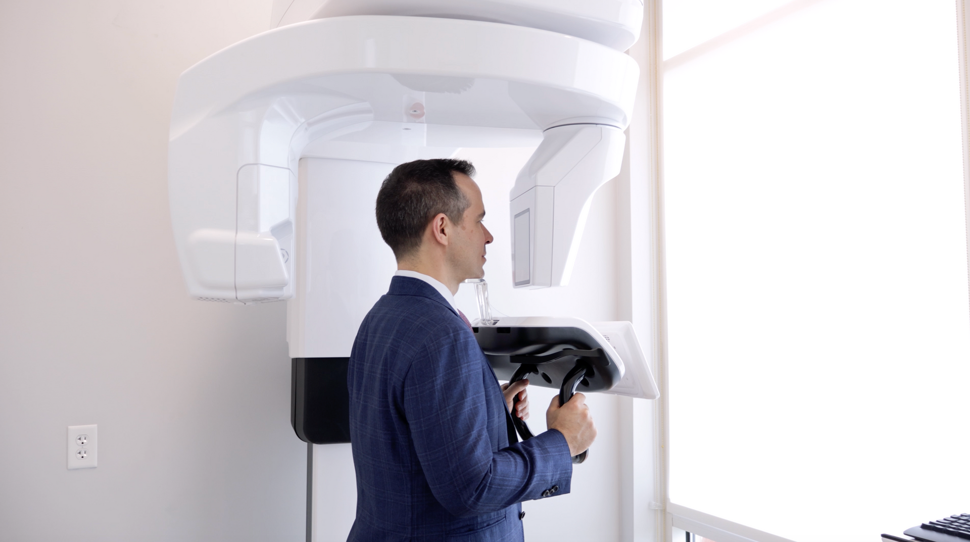 Woman using a medical imaging device with a screen showing a skull scan