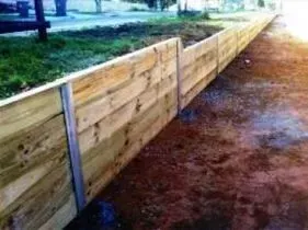 A wooden fence is sitting on top of a dirt road. A wooden fence is sitting on top of a dirt road.