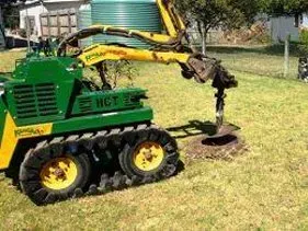 A green and yellow tractor is digging a hole in the ground. A green and yellow tractor is digging a hole in the ground.