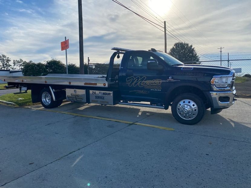 A blue tow truck is parked on the side of the road. A blue tow truck is parked on the side of the road.