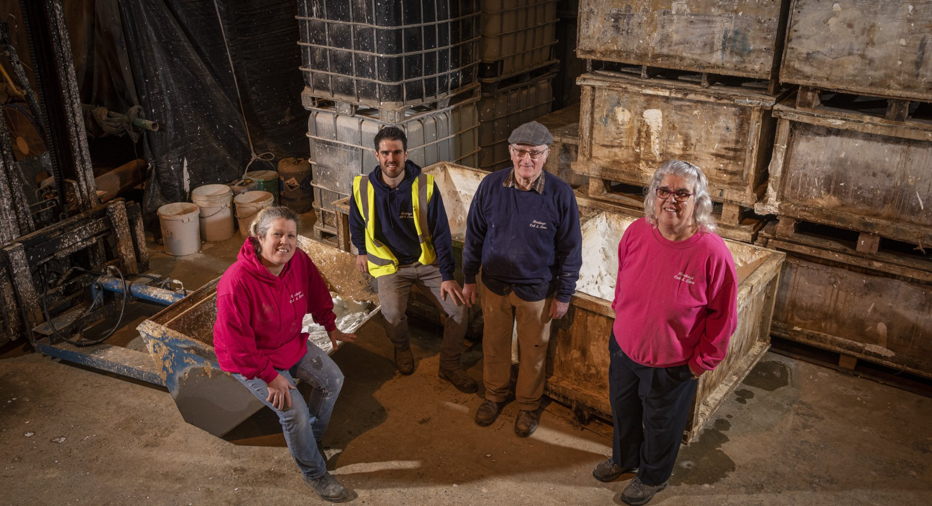 A group of people are standing next to each other in a warehouse.