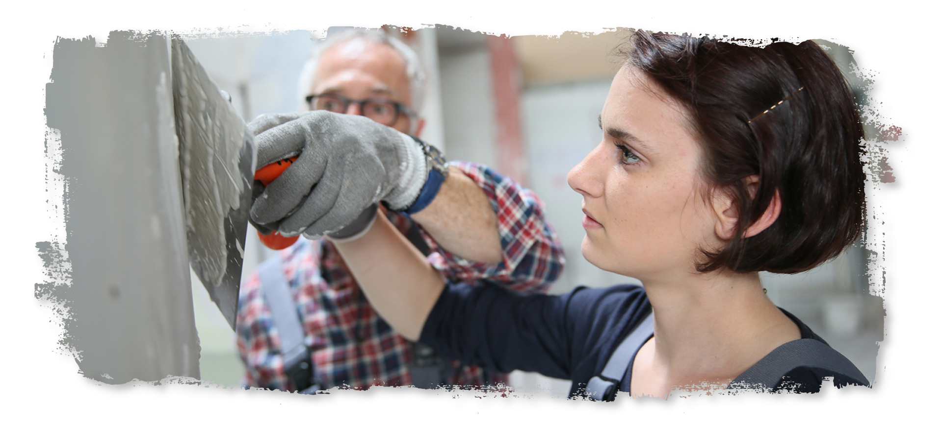 A man and a woman are working on a wall together.