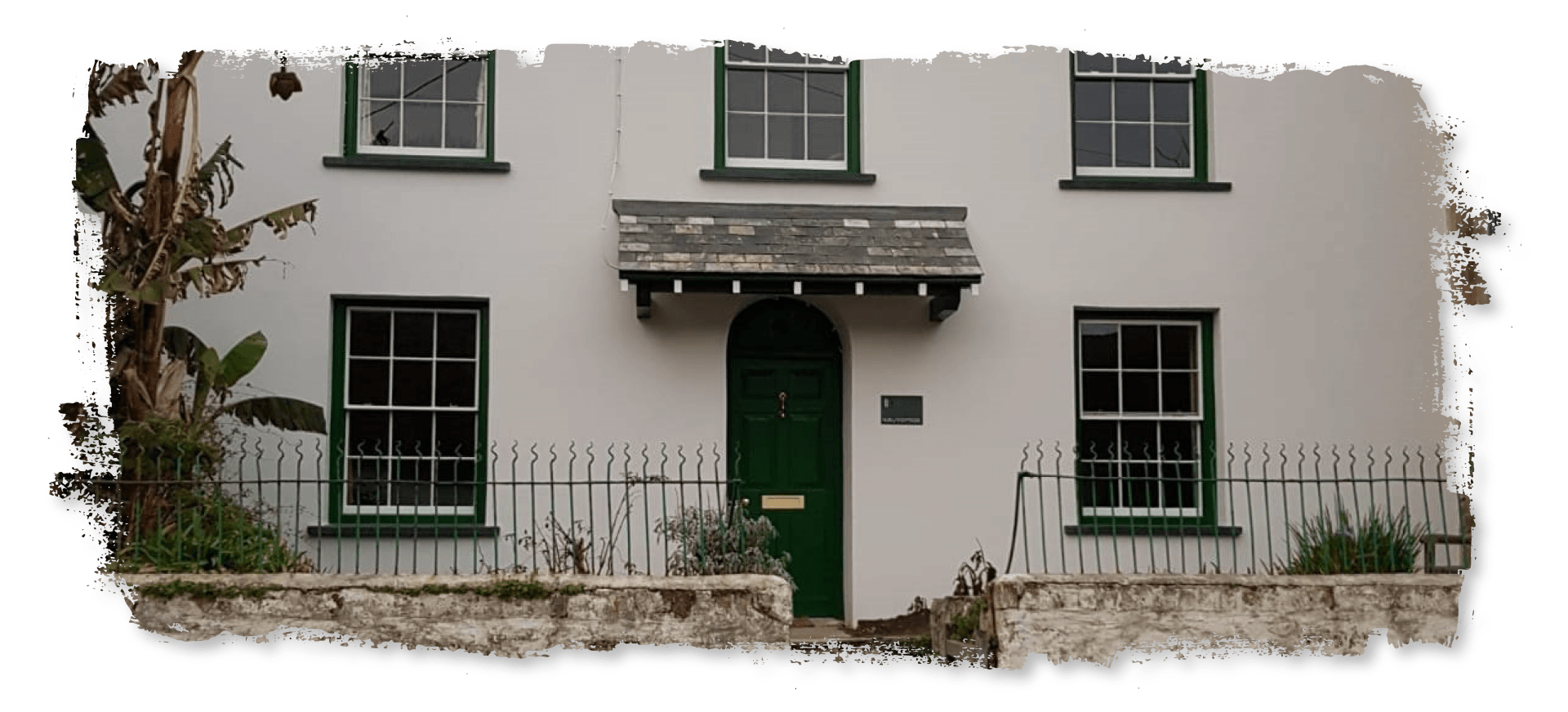 A white house with a green door and windows