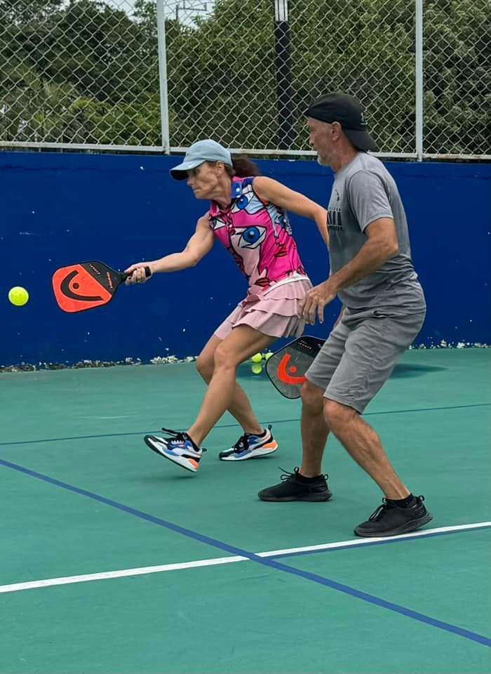 A man and a woman are playing tennis on a court