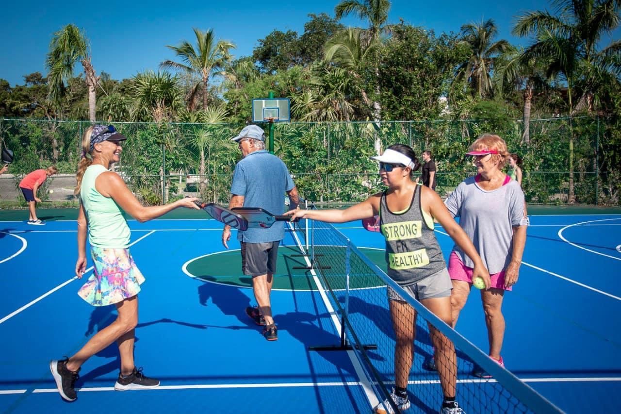 A group of people are shaking hands after a pickleball game at the Playa Del Carmen Pickleball Club in Playa Del Carmen, Mexico 