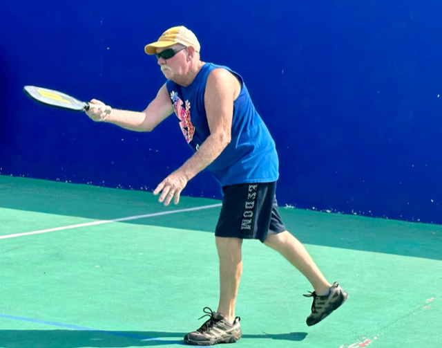 A man wearing a blue tank top and shorts with the word moose on them