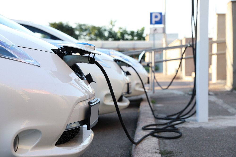 A Row of Electric Cars Are Being Charged at a Charging Station — Ray Smith Electrical in Nambucca Heads, NSW