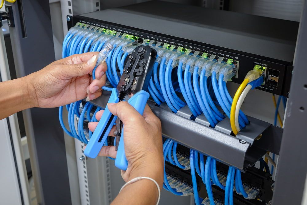 A Person is Working on a Server With a Pair of Pliers — Ray Smith Electrical in Korora, NSW