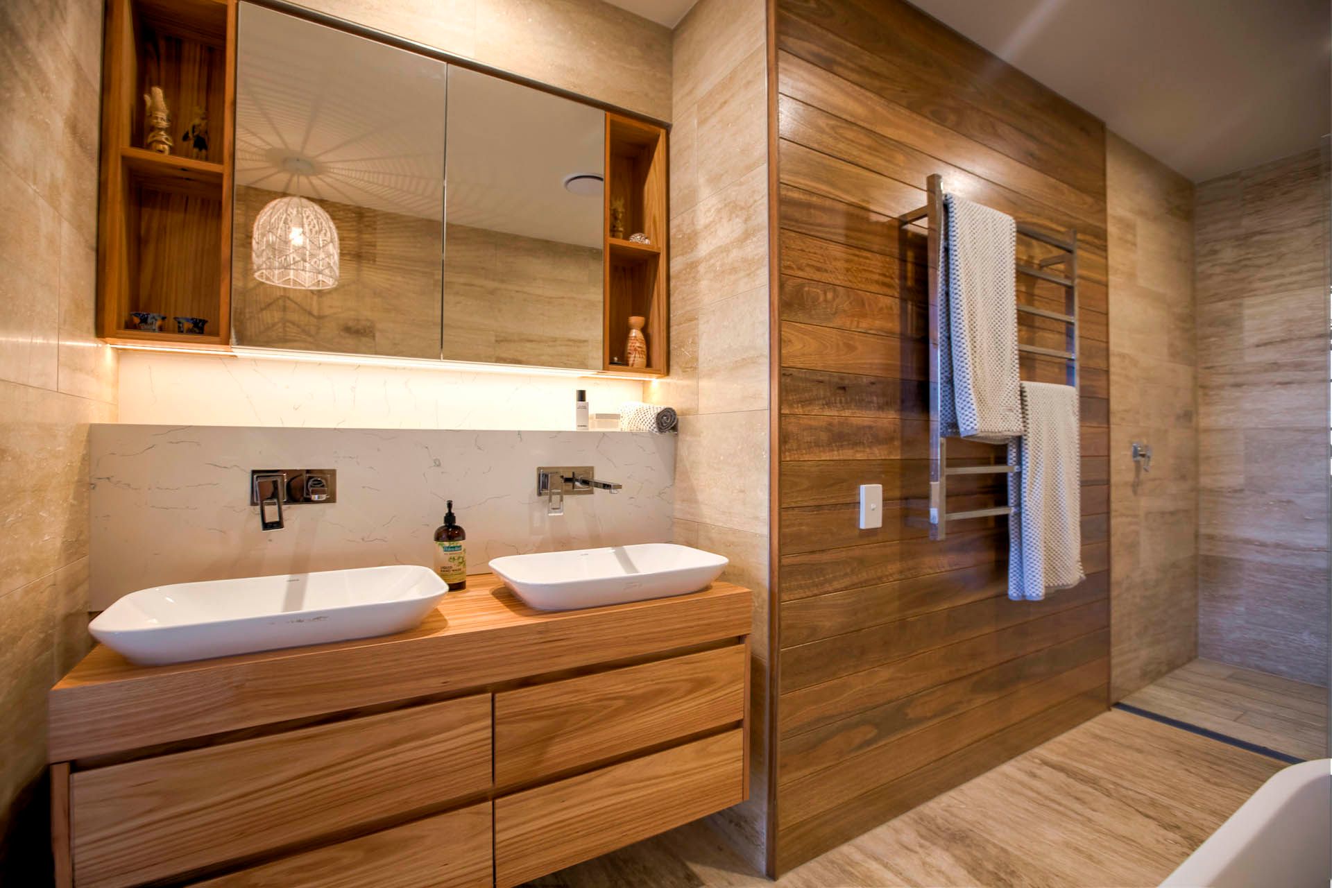 Bathroom with wooden vanity and wall paneling; two white sinks, mirror, and towel rack— Ray Smith Electrical in Korora, NSW