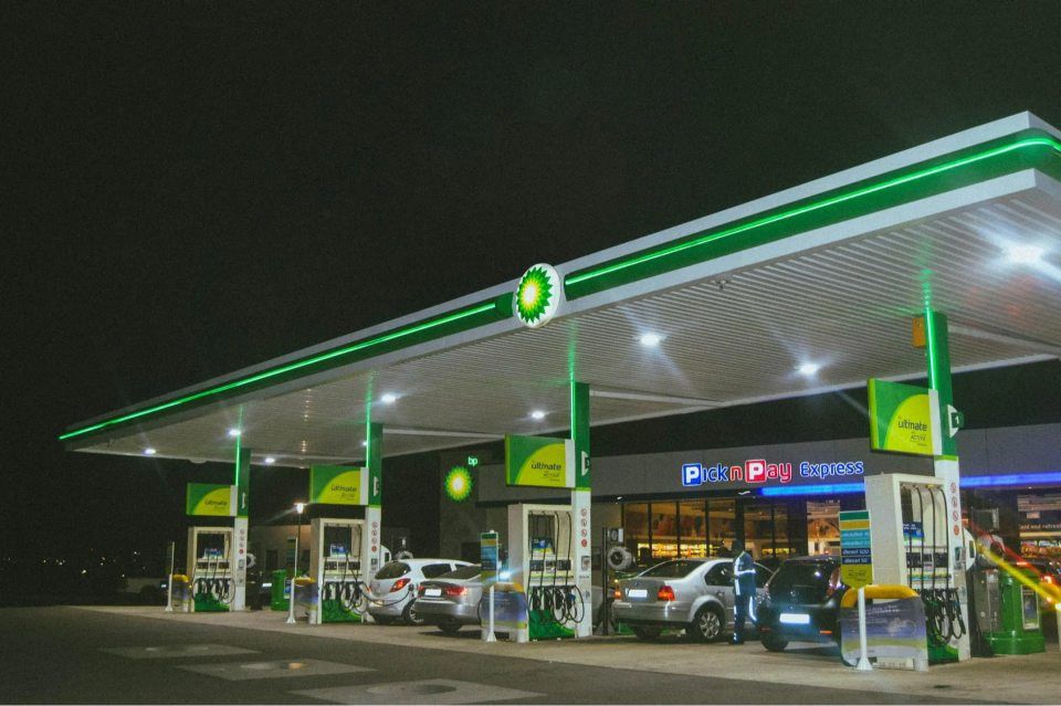 A Bp Gas Station at Night With Cars Parked in Front of It — Ray Smith Electrical in Korora, NSW