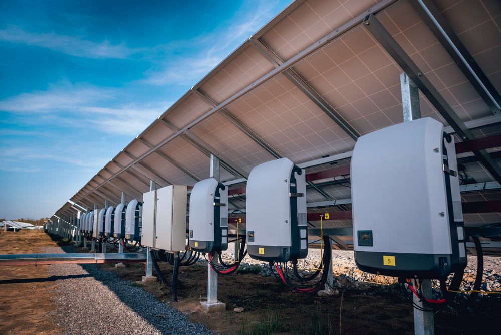 A Row of Solar Panels and Inverters in a Solar Farm — Ray Smith Electrical in Bellingen, NSW