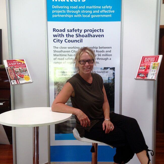 Woman Sitting at A Table in Front of A Banner — Rme in Sapphire, NSW