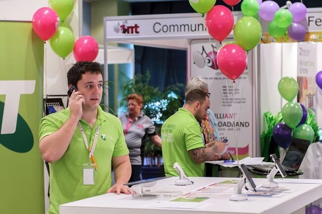 Man on Phone at A Booth with Staff — Rme in Sapphire, NSW