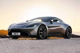 A silver sports car is parked on the side of a dirt road.