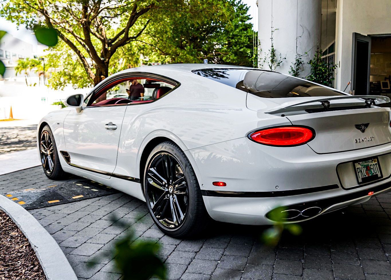 A white Bentley Continental GT is parked in a driveway.