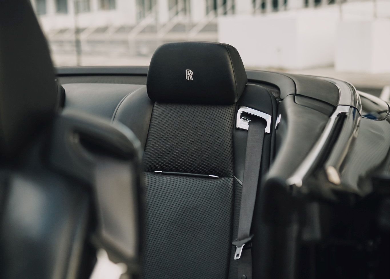 A close up of the back seat of a car with a seat belt.