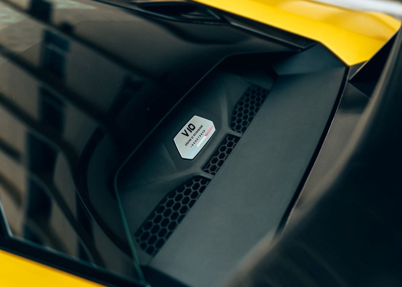A close up of the hood of a yellow car.