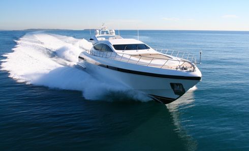 A large white yacht is floating on top of a large body of water.