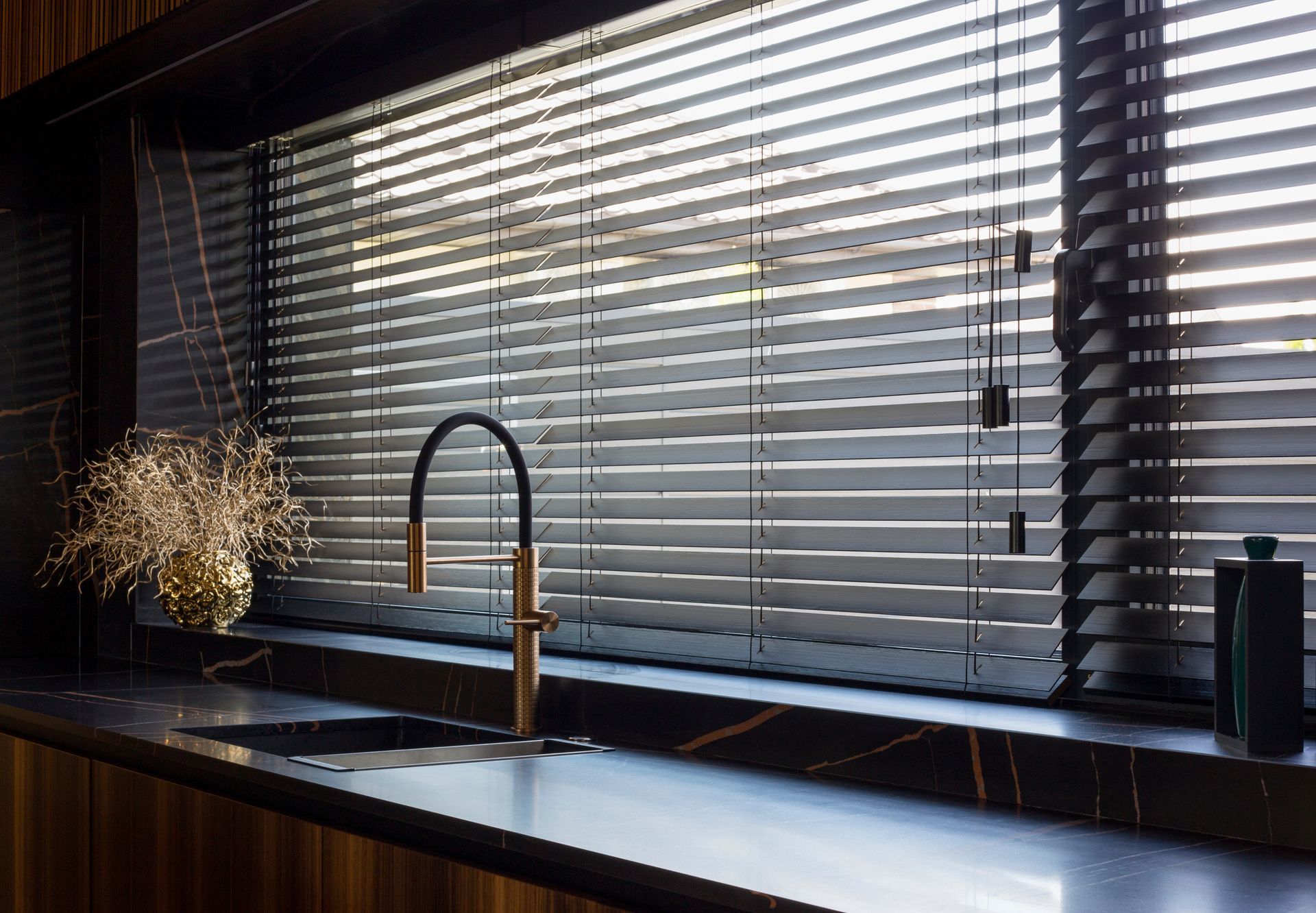 Faux wood kitchen blinds blocking light in a chic kitchen.  