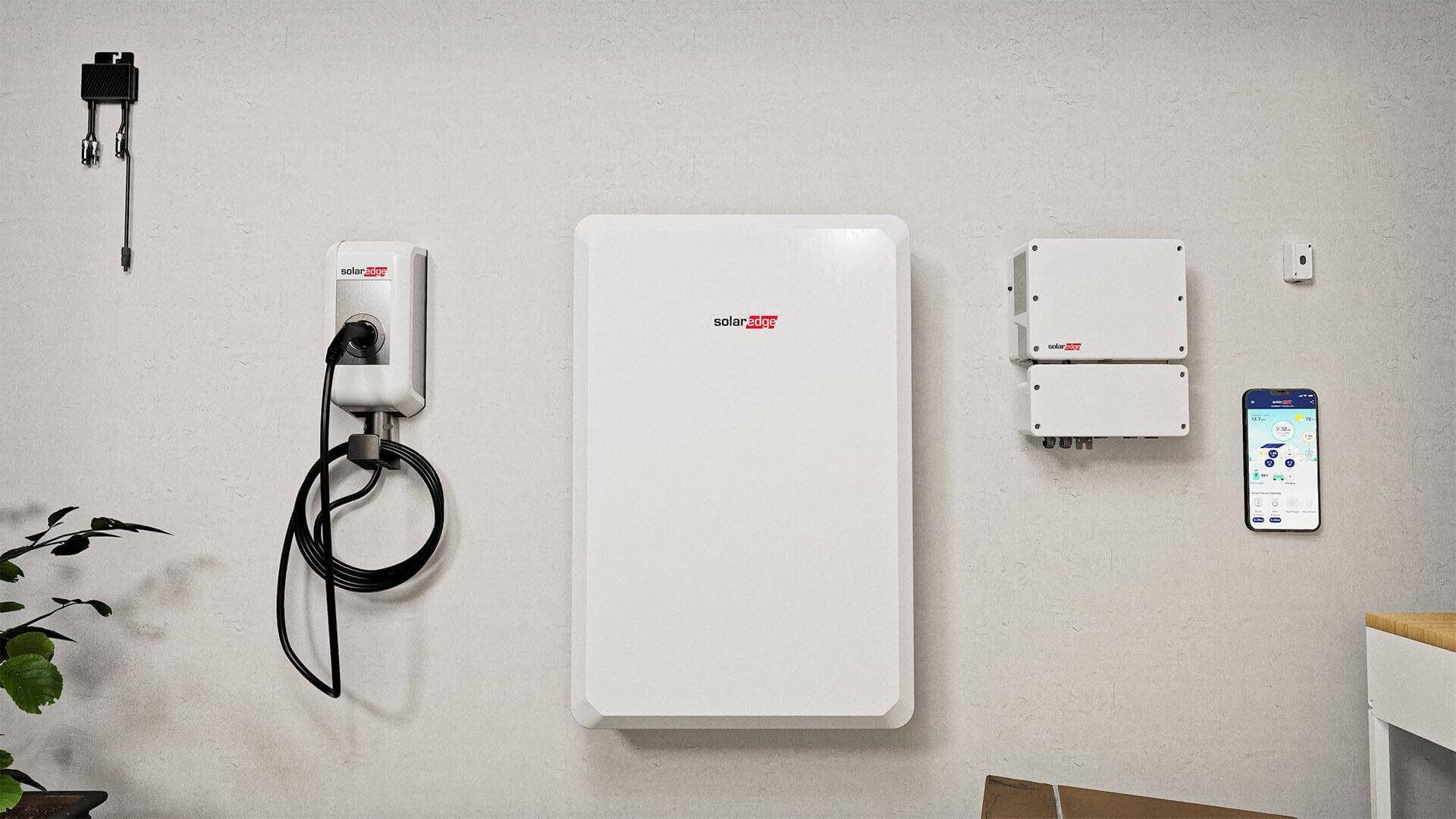 Wall-mounted home energy devices and charger on a white wall, with a smartphone nearby