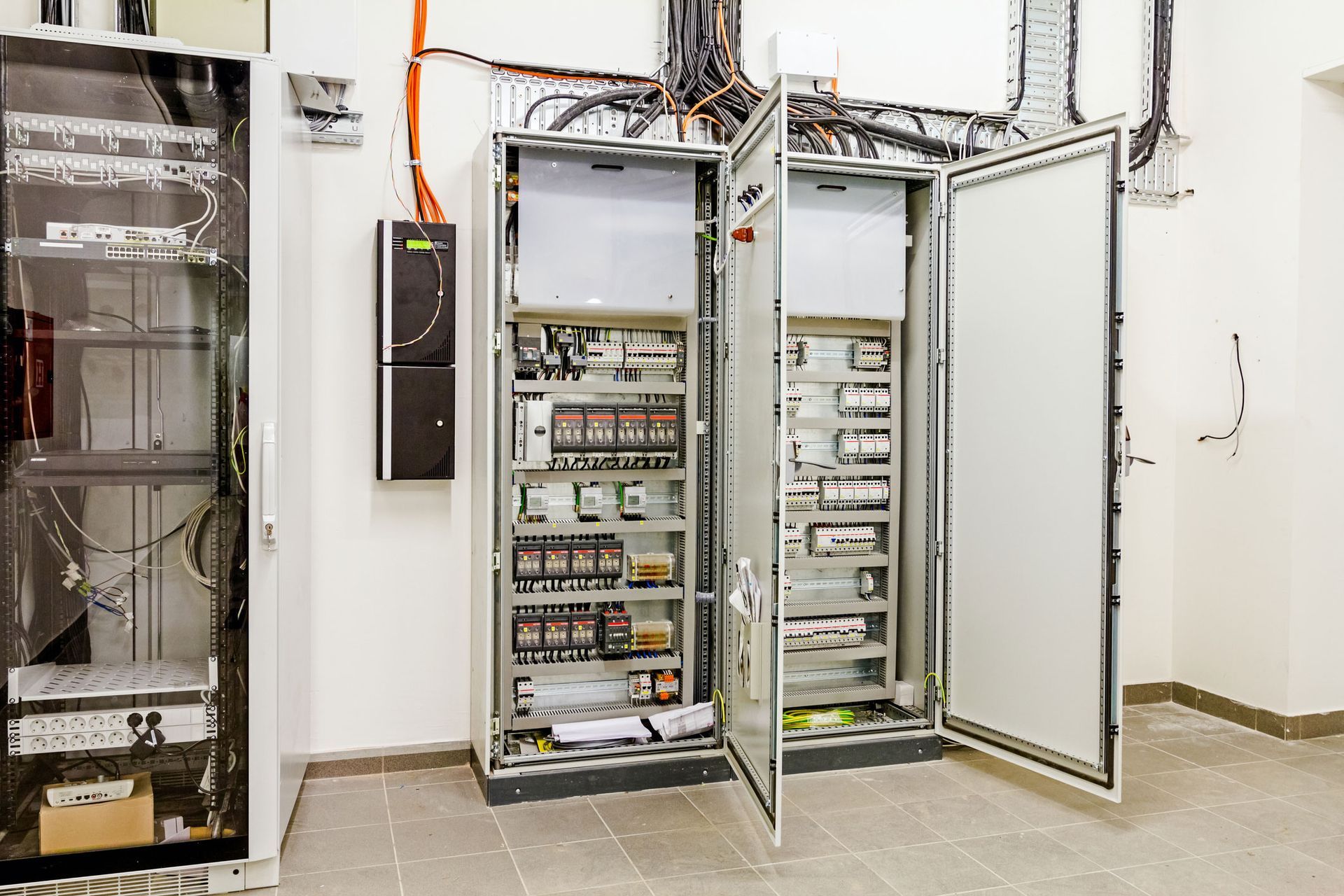 Electrical control panels in a room with the doors open.