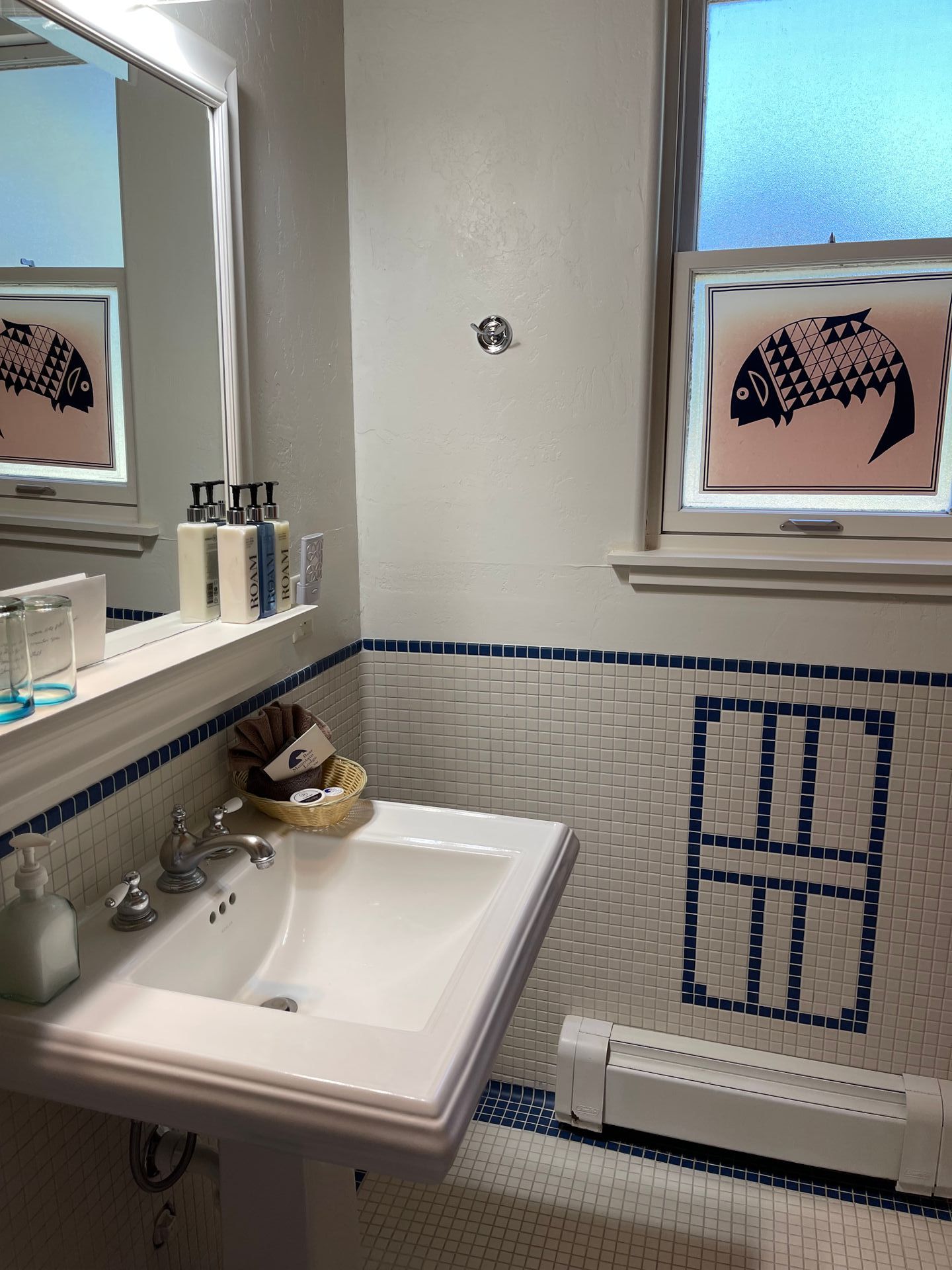 A bathroom with a sink a mirror and a window