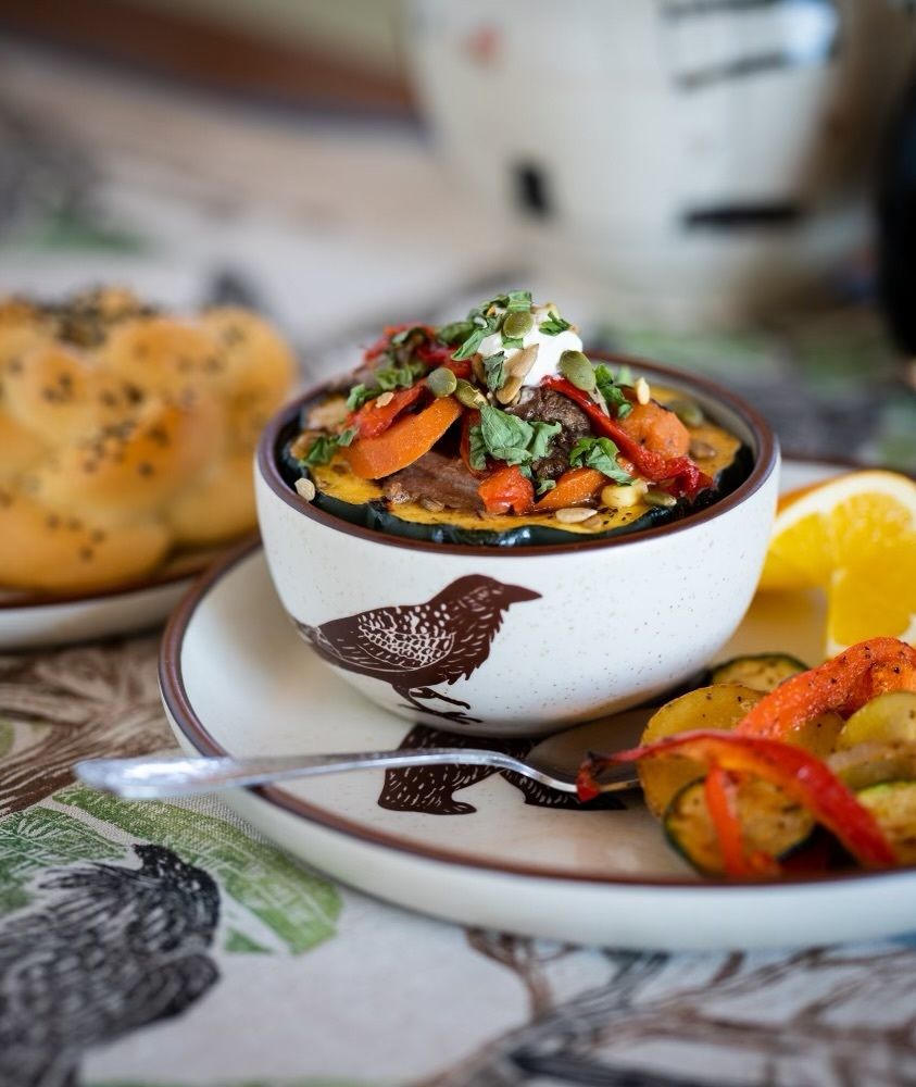 a bowl of food with vegetables on a plate with a fork .