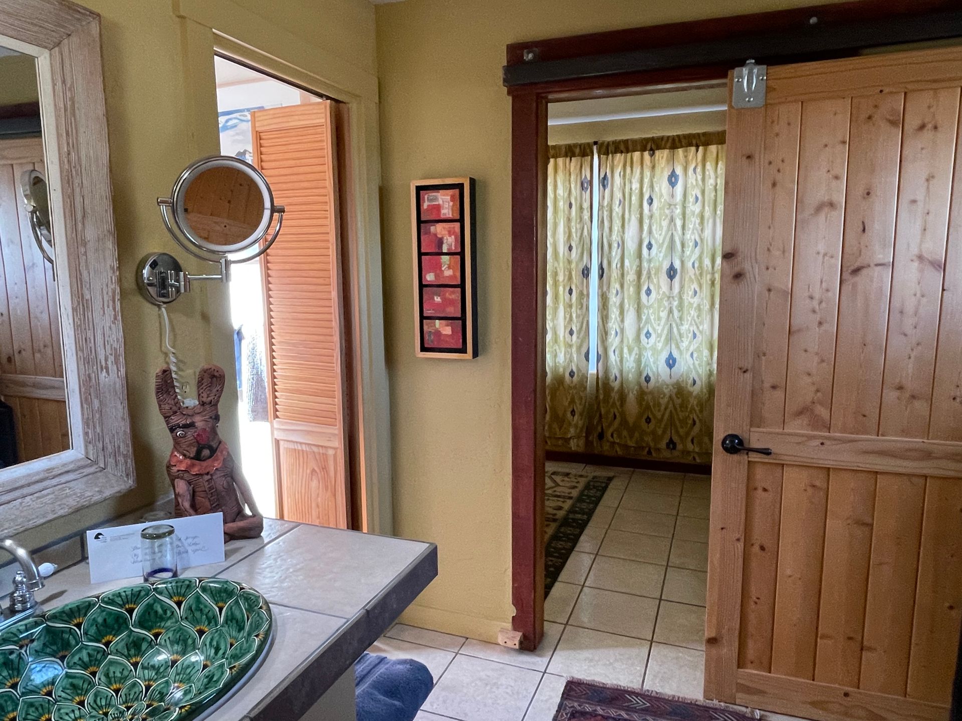 A bathroom with a sink a mirror and a wooden door