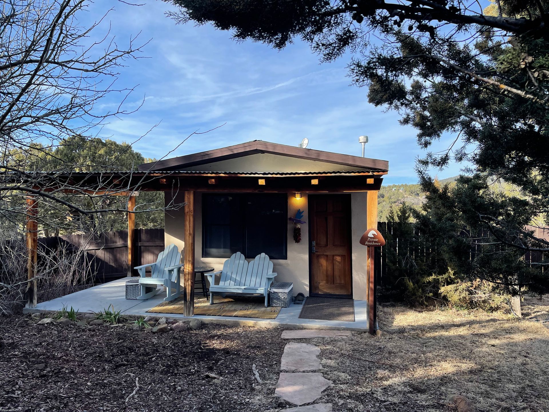 A small house with a porch and chairs in front of it