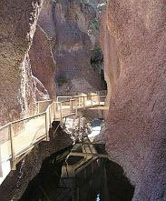 a bridge leading to a cave in the middle of a canyon .
