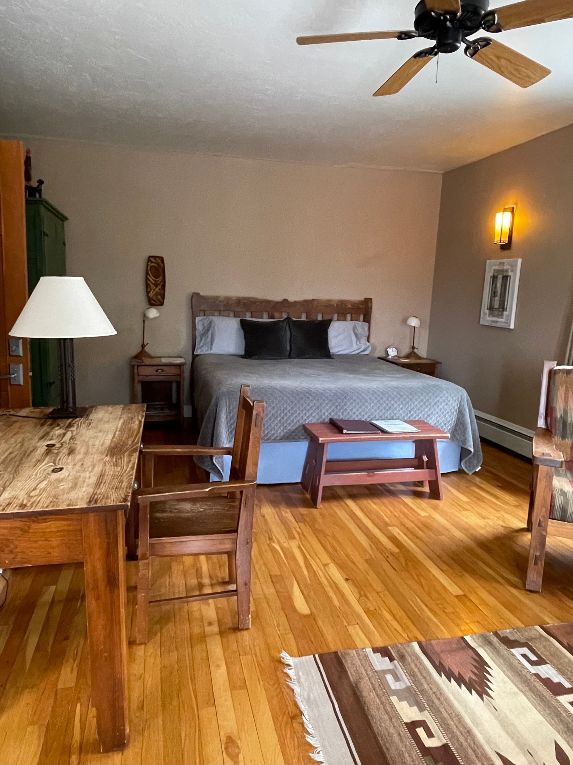 A bedroom with a large bed and a ceiling fan