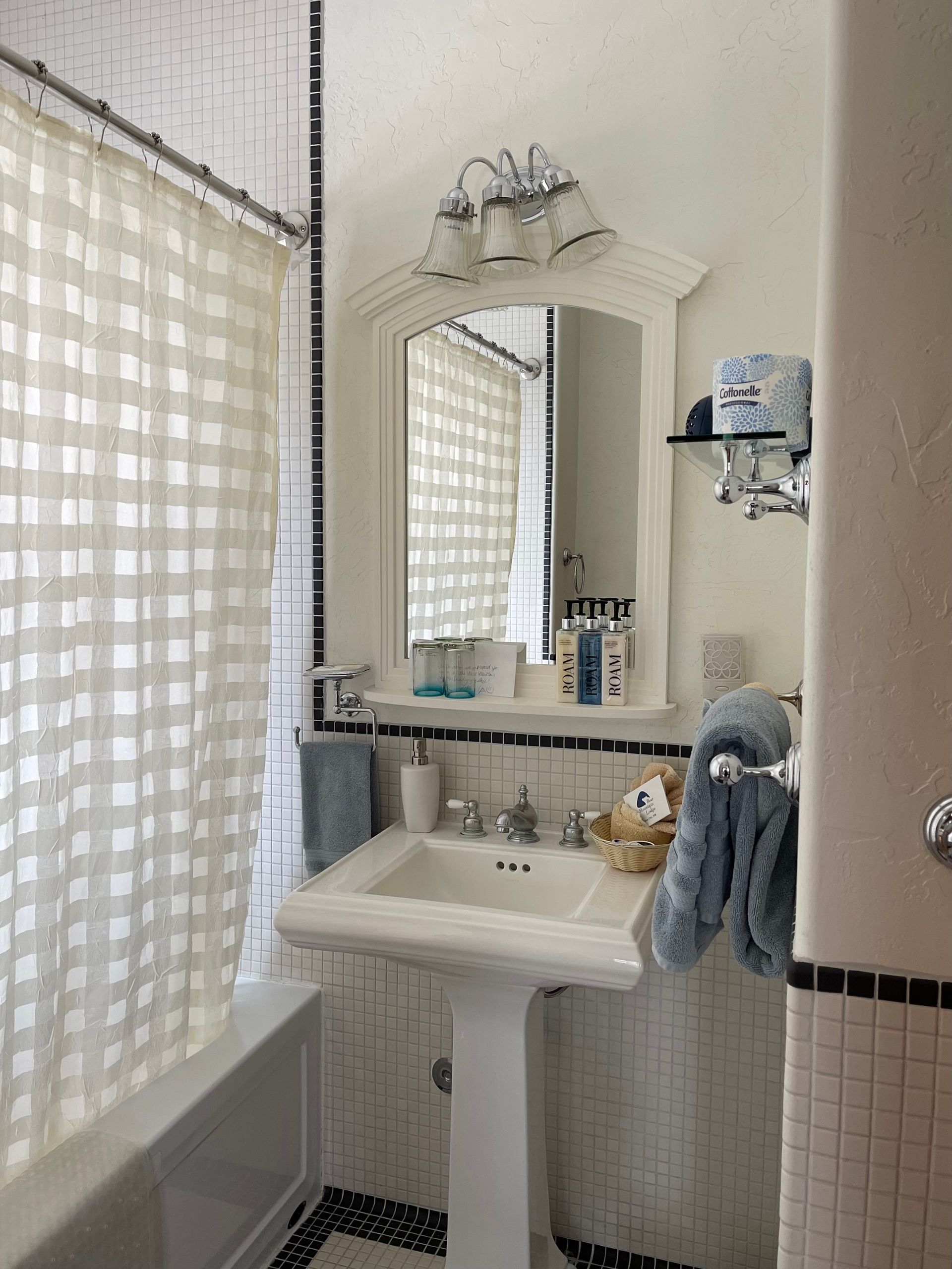 A bathroom with a pedestal sink and a mirror