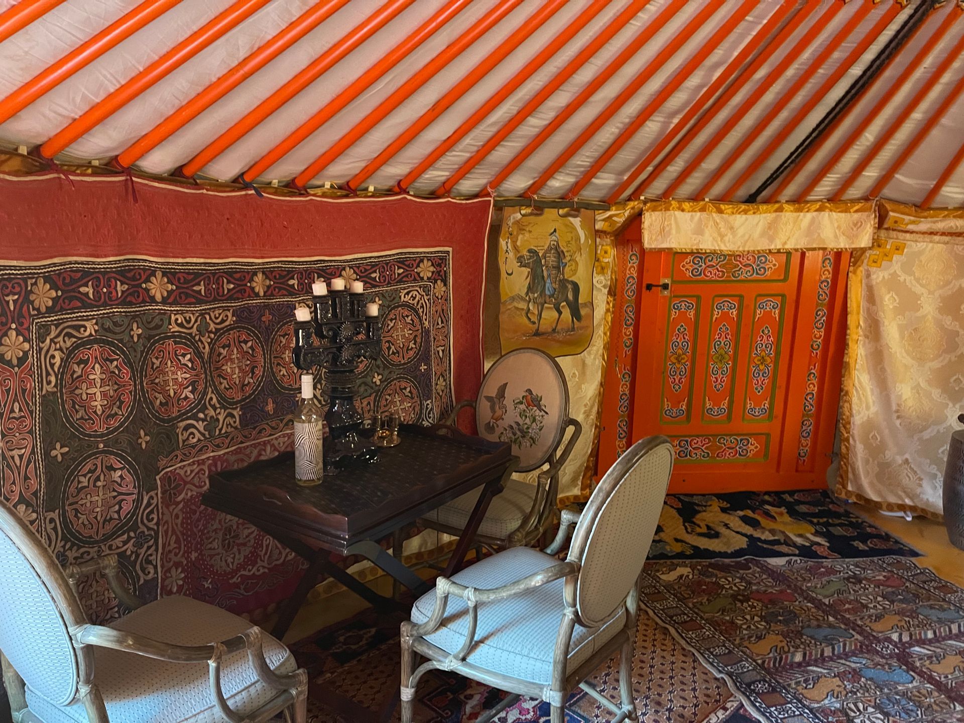 A room with a table and chairs inside of a yurt.