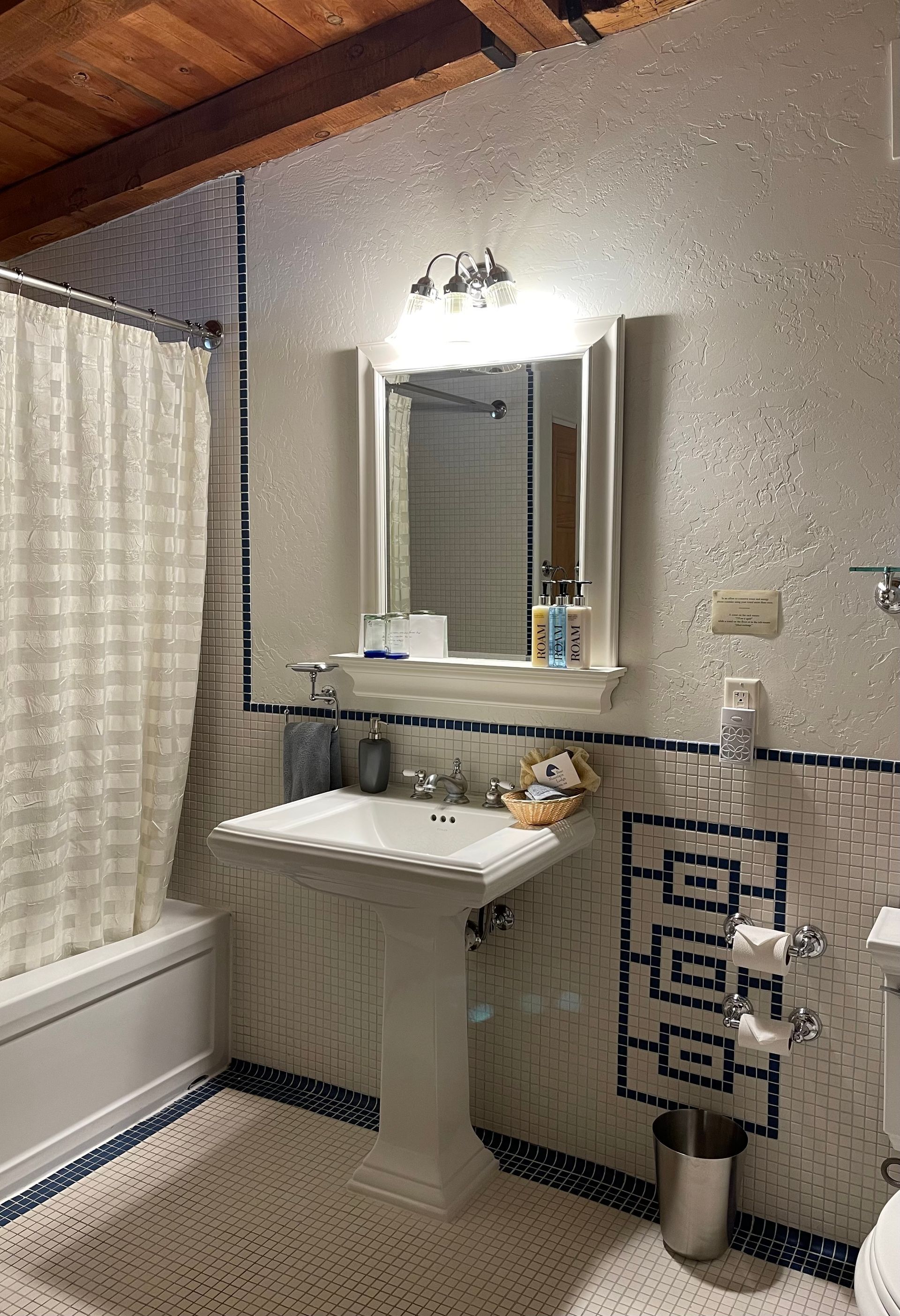 A bathroom with a sink , toilet , bathtub and mirror.
