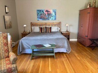 A bedroom with a large bed and a chair