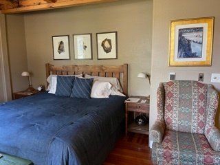 A bedroom with a king size bed and a chair