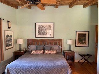 A bedroom with a bed and a ceiling fan
