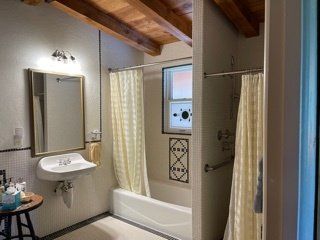 A bathroom with a sink , tub , shower and mirror.
