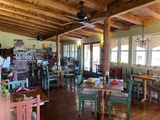 A restaurant with tables and chairs and a ceiling fan.