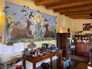 A room with a painting of two deer on the wall