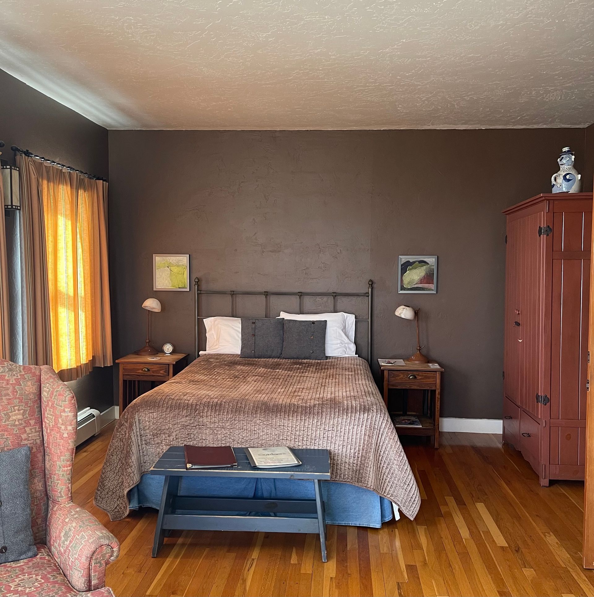 A bedroom with a large bed and a chair