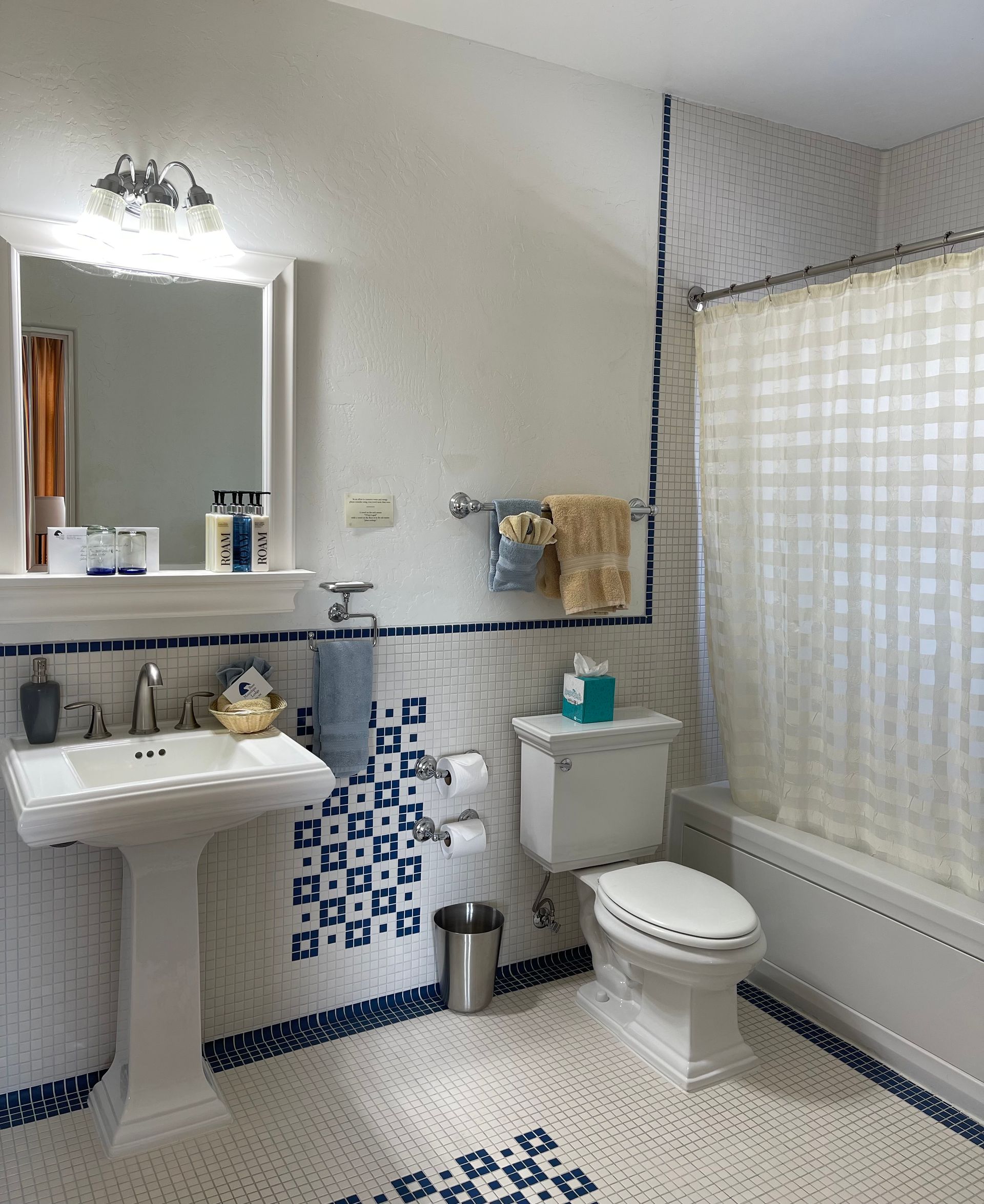 A bathroom with a sink , toilet , shower and mirror