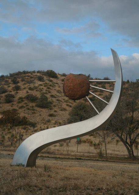 A sculpture with a large rock on top of it
