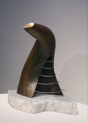 A sculpture is sitting on a white marble base